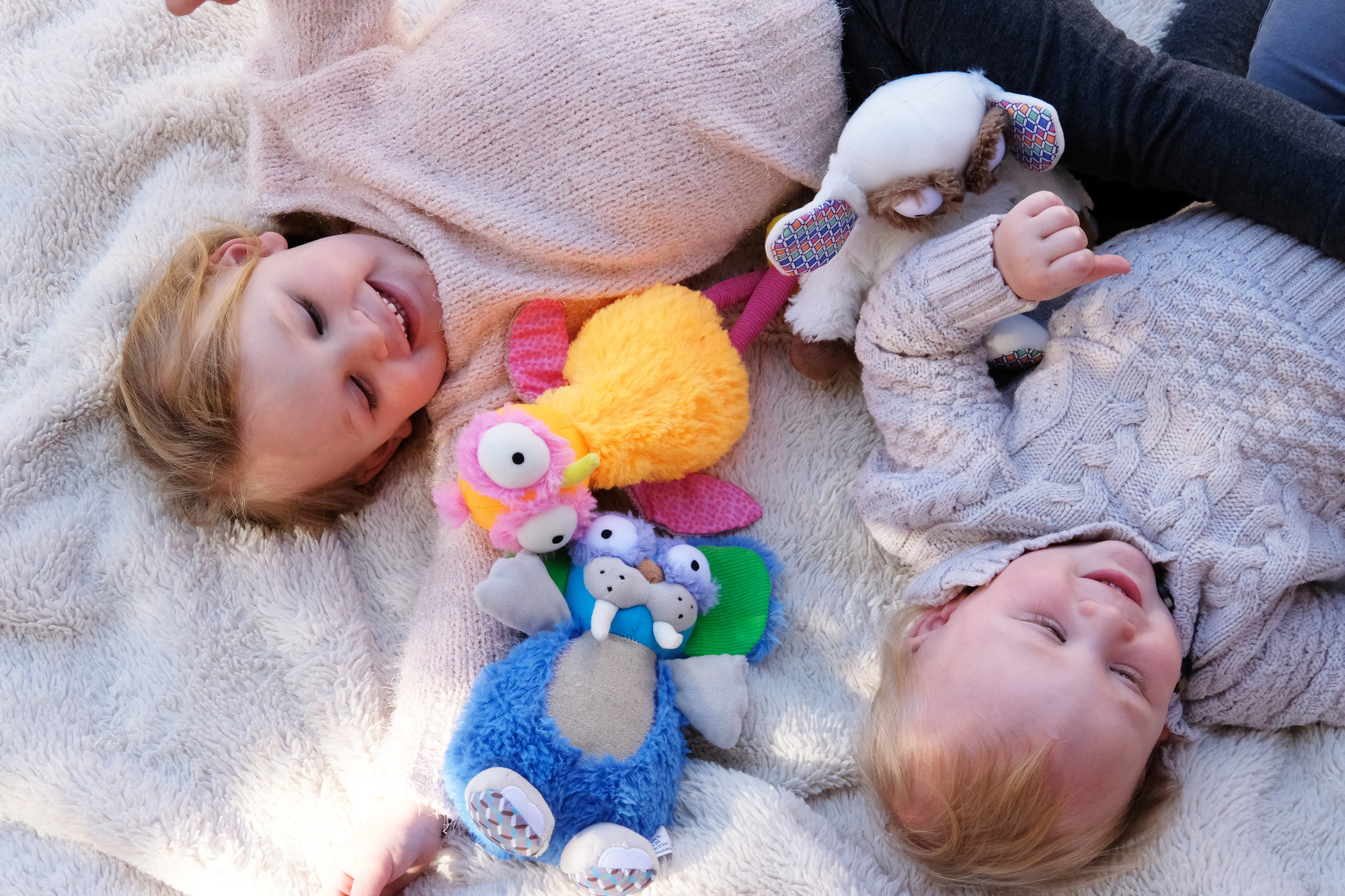 siblings and colorful plush toys